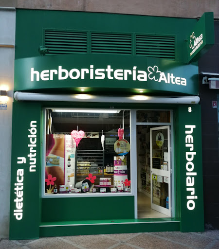 Fachada de la Herboristería Altea en Torremolinos: rótulo blanco sobre fondo verde, escaparate y laterales con los letreros 'dietética y nutrición' y 'herbolario'